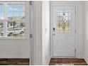 Bright foyer featuring a window, wood-look flooring and a decorative front door at 128 Cherry Birch St, Mooresville, NC 28117