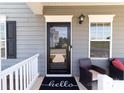 Inviting front door with a 'hello' mat and decorative potted plants at 146 Kerri Dawn Ln, Locust, NC 28097