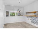 Dining room with mirrored wall, decorative light fixture, and view of living room at 1604 Sharon W Rd, Charlotte, NC 28210