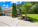 Spacious two-car garage with a concrete driveway, complemented by colorful landscaping and lush green lawn at 168 Blue Ridge Trl, Mooresville, NC 28117