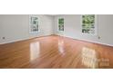 Bright bedroom with gleaming hardwood floors and three windows creating a warm and inviting atmosphere at 2020 Dawnshire Dr, Gastonia, NC 28054