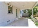 View of the covered patio showing the brick exterior, access door and grassy backyard at 2333 Greenland Ave, Charlotte, NC 28208