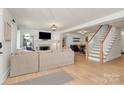 Bright living room featuring hardwood floors, fireplace, and staircase to upper level at 2333 Greenland Ave, Charlotte, NC 28208