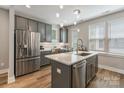 Kitchen featuring stainless steel appliances, gray cabinets, quartz countertop, and light hardwood floors at 2969 Simpson Dr, Charlotte, NC 28205