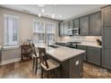 Kitchen with grey cabinets, quartz countertop, island, stainless appliances, and stylish pendant lighting at 2969 Simpson Dr, Charlotte, NC 28205