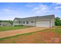 Single story home with grey siding, a green lawn, and an attached two car garage at 308 Laurel Ridge Dr, Lincolnton, NC 28092