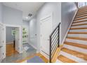 Inviting entryway with stylish staircase, modern door, neutral paint, tile flooring, and views to the yard at 327 S Turner Ave, Charlotte, NC 28208