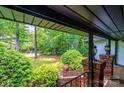 Charming covered porch showcasing brick accents, lush greenery, and an inviting outdoor space at 4275 Herman Sipe Rd, Conover, NC 28613