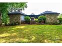 Charming stone and siding home with lush landscaping, a brick entrance, and a green lawn at 4275 Herman Sipe Rd, Conover, NC 28613