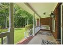 Inviting front porch with swing, brick accents, and well-maintained landscaping, perfect for relaxing outdoors at 4824 Waxhaw Farms Rd, Waxhaw, NC 28173