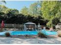 Backyard pool with gazebo and green shrubbery along the fence at 5017 Celeste Ct, Charlotte, NC 27609