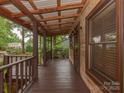 Covered porch with wood floors and ceiling, showcasing the log cabin's natural aesthetic at 5109 Walnut Grove Ln, Charlotte, NC 28227