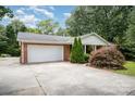 A single-Gathering brick home with an attached garage and a well-manicured yard at 6300 Morehead Rd, Harrisburg, NC 28075