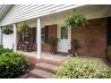 Inviting front porch with brick steps, rocking chairs, and potted plants at 6300 Morehead Rd, Harrisburg, NC 28075