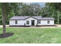 Beautiful house with black roof and white siding and black trim sits on a large grassy yard with trees at 6310 Forney Hill Rd, Denver, NC 28037