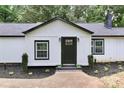 Charming house with black door, white siding and manicured front garden and sidewalk to the door at 6310 Forney Hill Rd, Denver, NC 28037