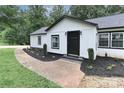 Charming home featuring white siding, a black front door, and beautifully landscaped front yard at 6310 Forney Hill Rd, Denver, NC 28037