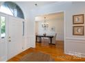 Elegant dining room showcasing hardwood floors, chandelier, and wainscoting with easy access from the front door at 6507 Fairway Point Dr, Charlotte, NC 28269