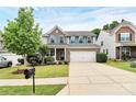 Two-story home featuring brick and gray siding, a two-car garage, well-maintained lawn and landscaped front yard at 6961 Liverpool Ct, Fort Mill, SC 29707