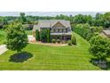 Expansive aerial view of a stately brick home with a well-maintained lawn and lush, mature landscaping throughout the property at 8137 Caliterra Dr, Charlotte, NC 28227