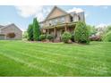 Lovely two-story home has a lush green lawn with manicured shrubbery and large shade trees in a desirable neighborhood at 8137 Caliterra Dr, Charlotte, NC 28227
