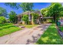 Traditional brick home featuring a covered front porch, carport and well-maintained landscaping at 823 Yuma St, Charlotte, NC 28213