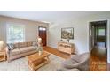 Staged living room with hardwood floors, area rug, and natural light from the window at 823 Yuma St, Charlotte, NC 28213