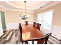 Elegant dining room with a wooden table, chandelier lighting, and stylish flooring at 9792 Ravenscroft Nw Ln, Concord, NC 28027
