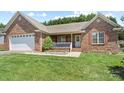 Well-maintained brick home with a manicured lawn and attached two-car garage at 1011 Atherstone Nw St, Conover, NC 28613