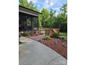 Inviting backyard with wooden deck, screened-in porch, and professionally landscaped features at 103 Northchase Dr, Concord, NC 28027