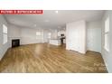 Open-concept living room with hardwood floors, fireplace, recessed lighting, and an adjacent kitchen area at 11209 Cardinal Creek Ave, Charlotte, NC 28215