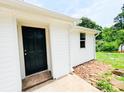 Close-up of the home's entrance featuring a black front door and white siding at 129 Williams Rd, Bessemer City, NC 28016