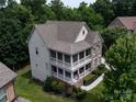 A bird's-eye view showcasing the home's backyard, two-story porch, and lush surrounding greenery at 14010 Promenade Dr, Huntersville, NC 28078
