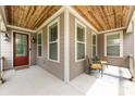 Inviting porch featuring a wood ceiling, seating, and a charming entrance door at 14010 Promenade Dr, Huntersville, NC 28078