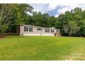 Inviting single Gathering home featuring a manicured lawn surrounded by lush green trees at 159 Blackmon Pond Rd, Lancaster, SC 29720