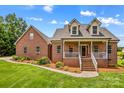 Charming brick home featuring manicured lawn, inviting front porch, and dormer windows at 159 Forest Abbey Ln, China Grove, NC 28023