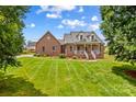 Classic brick home featuring lush green lawn, inviting porch, and dormer windows at 159 Forest Abbey Ln, China Grove, NC 28023