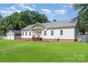 Features a well-maintained lawn, a detached garage and a white house with a gray roof at 1593 Bloomfield Rd, Rock Hill, SC 29732