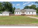 White exterior of the home with detached garage, view from across the street at 1593 Bloomfield Rd, Rock Hill, SC 29732