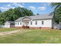 View of the white exterior of the home with a well-manicured lawn and a detached garage at 1593 Bloomfield Rd, Rock Hill, SC 29732