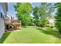 Expansive backyard with lush green lawn, mature trees, deck, and patio at 169 Halifax Dr, Fort Mill, SC 29707