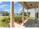 Inviting covered front porch with landscaping, offering a cozy entry to the home at 1691 Ashley Lynn Ct, Stanfield, NC 28163