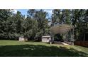 Spacious backyard featuring two storage sheds and a large metal carport for boats or recreational vehicles at 179 Delwood Ct, Mount Gilead, NC 27371