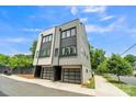 This modern home showcases its exterior with a two-car garage and well-manicured sidewalk at 1933 W Trade St, Charlotte, NC 28216