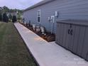 Well-maintained side yard with decorative lighting, walkway, and a storage shed at 195 Willow Valley Dr, Mooresville, NC 28115