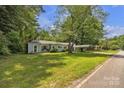 Single-story home has a well-maintained lawn, covered carport, and mature trees at 2222 19Th Ne Ave, Hickory, NC 28601