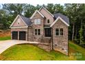 Charming brick two-story home featuring a two-car garage and lush green landscaping at 240 Mark Ryan Ln, Dallas, NC 28034