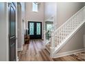 Grand two-story foyer with elegant staircase, decorative front doors, and wood flooring at 240 Mark Ryan Ln, Dallas, NC 28034