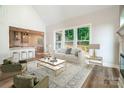 Bright living room with large windows, a modern fireplace, and an open view into the kitchen at 240 Mark Ryan Ln, Dallas, NC 28034