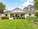 Beautiful one-story house featuring white brick, a welcoming front porch, and a well-manicured lawn at 2636 Chilton Pl, Charlotte, NC 28207